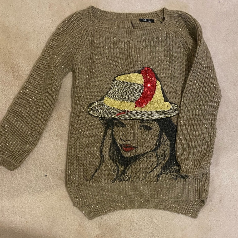 I am selling A size Xs gold-coloured sweater with a girl's print on the front.